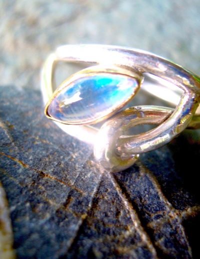 A silver, gold and blue moonstone ring
